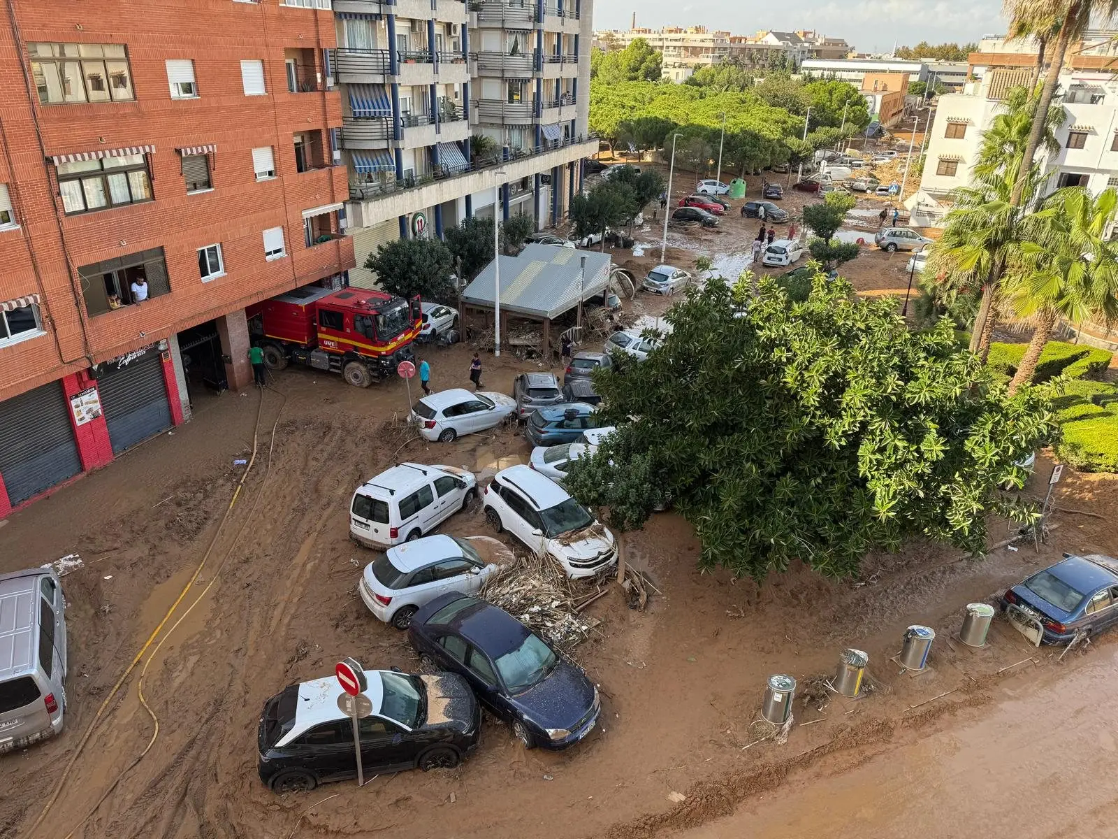 Calle de Catarroja cubierta de barro y con coches amontonados tras la DANA
